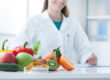 Doctor smiles next to healthy fruits and vegetables as she is asked "what is medical weight loss?"