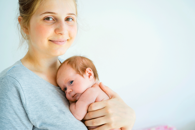 Woman holds her baby after talking to a friend about how to optimize hormones
