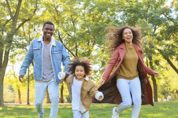 Family walking together outdoors in a park on a sunny day