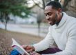 Man sitting outdoors reading, taking time to consider his options