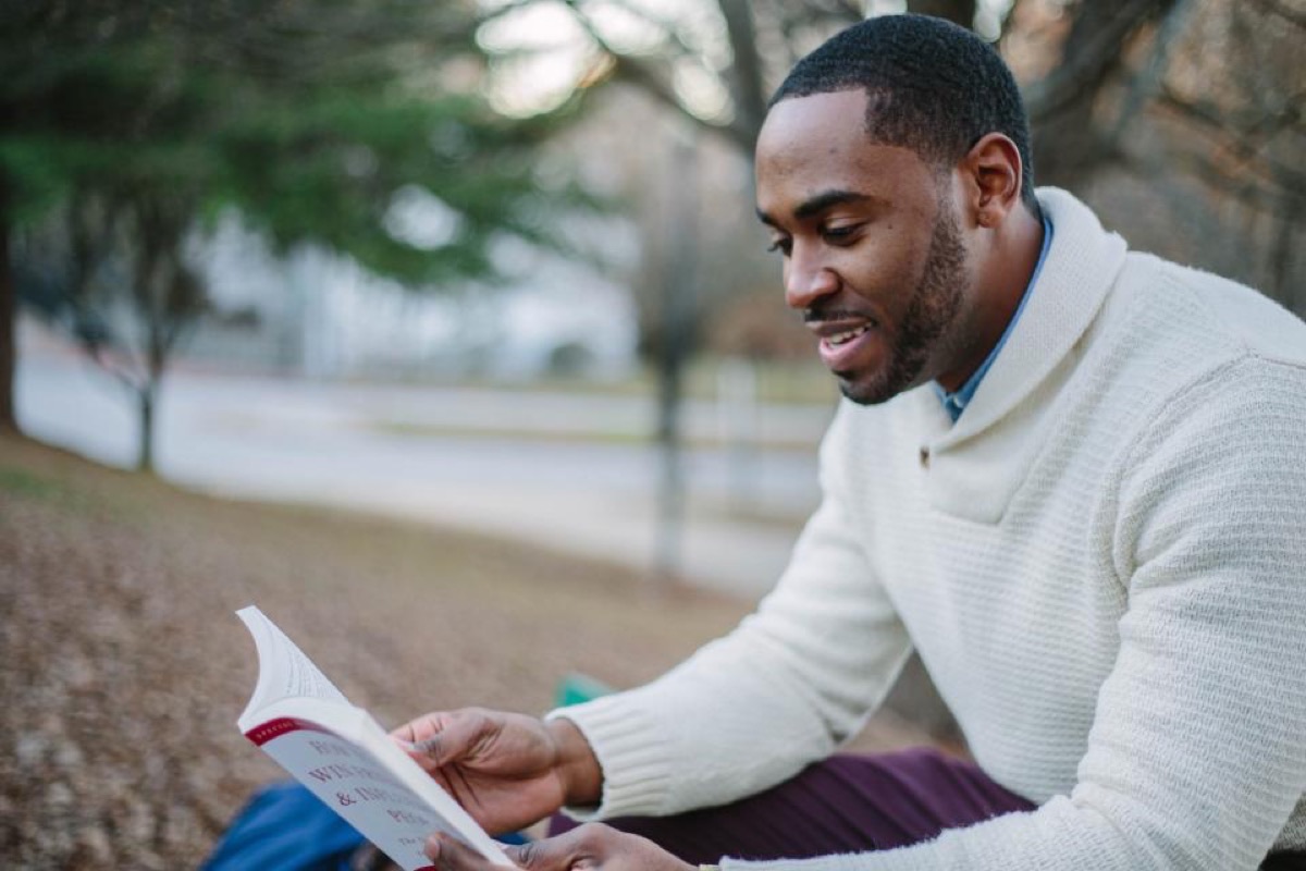 Man sitting outdoors reading, taking time to consider his options Man sitting outdoors reading, taking time to consider his options
